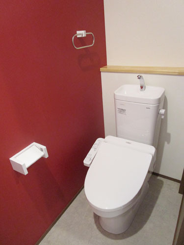 赤い壁が特徴のトイレ